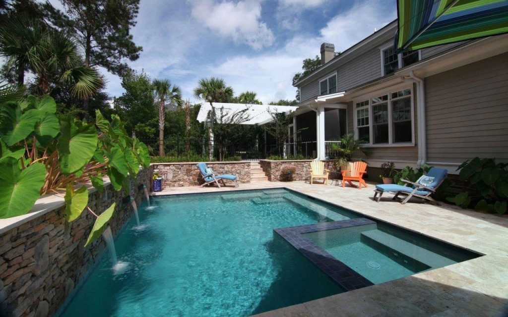 Pool with spa and a stone wall with waterfalls | Aqua Blue Pools