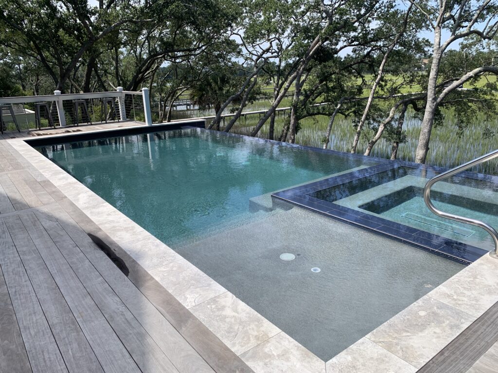 Infinity Pool overlooking marsh and trees with Inset Spa and Sun Ledge