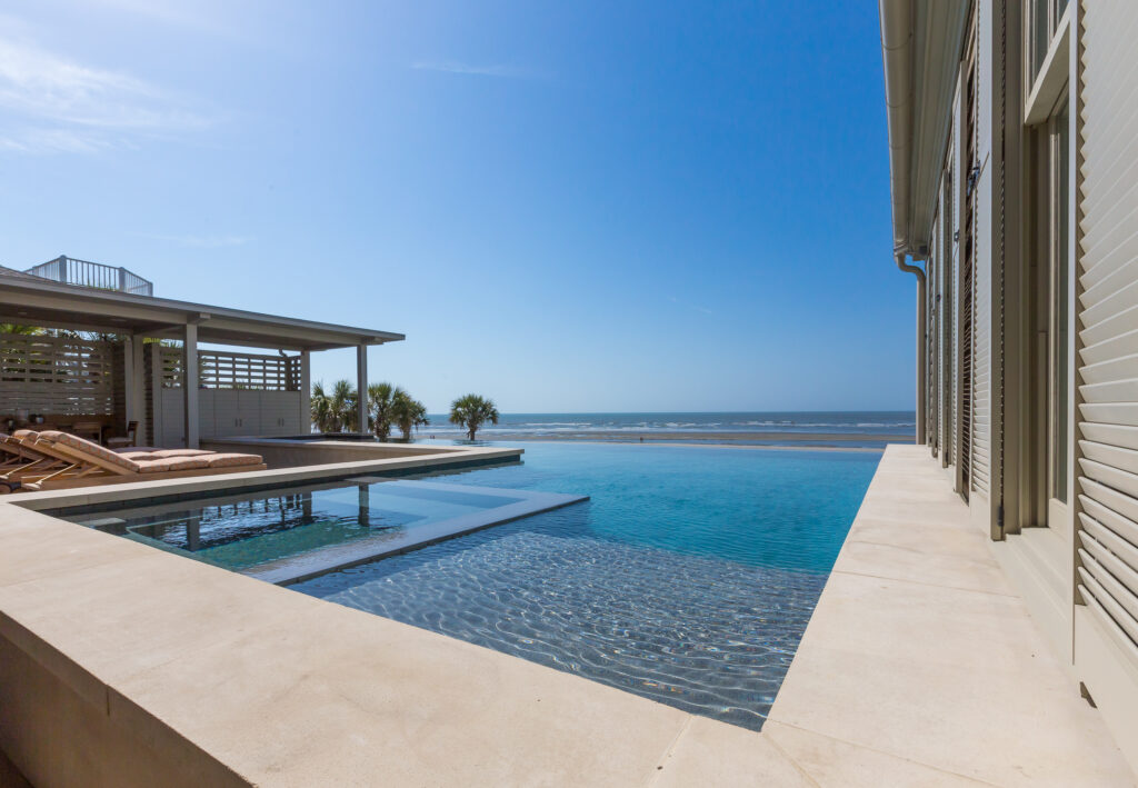 Pool with no edge overlooking beach and ocean